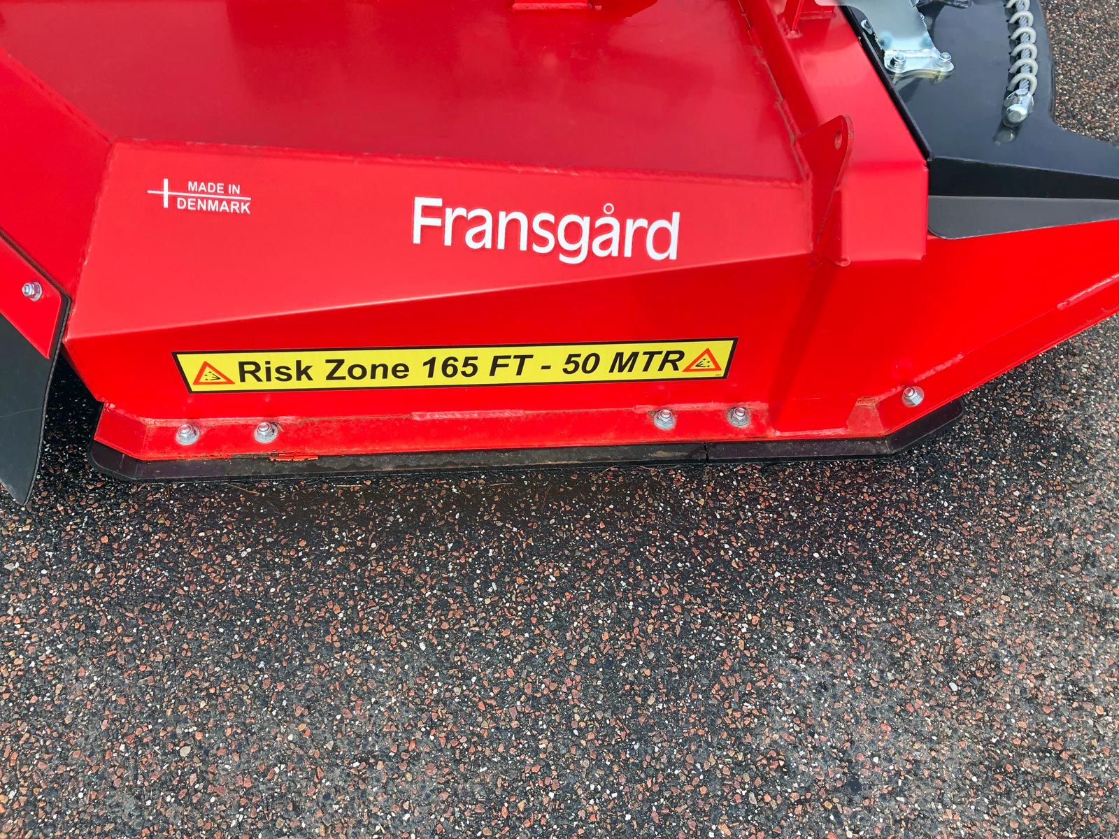 En slidskinne monteret på rød kæderydder maskine.