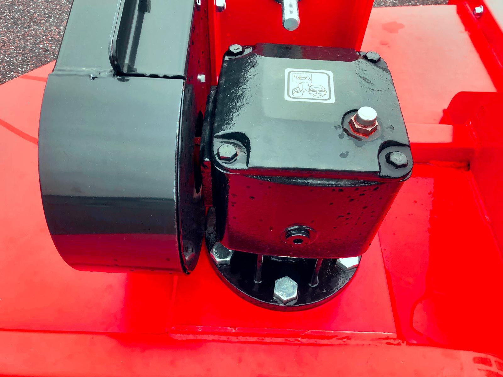 Et nærbillede af en rød maskine med en sort gearkasse