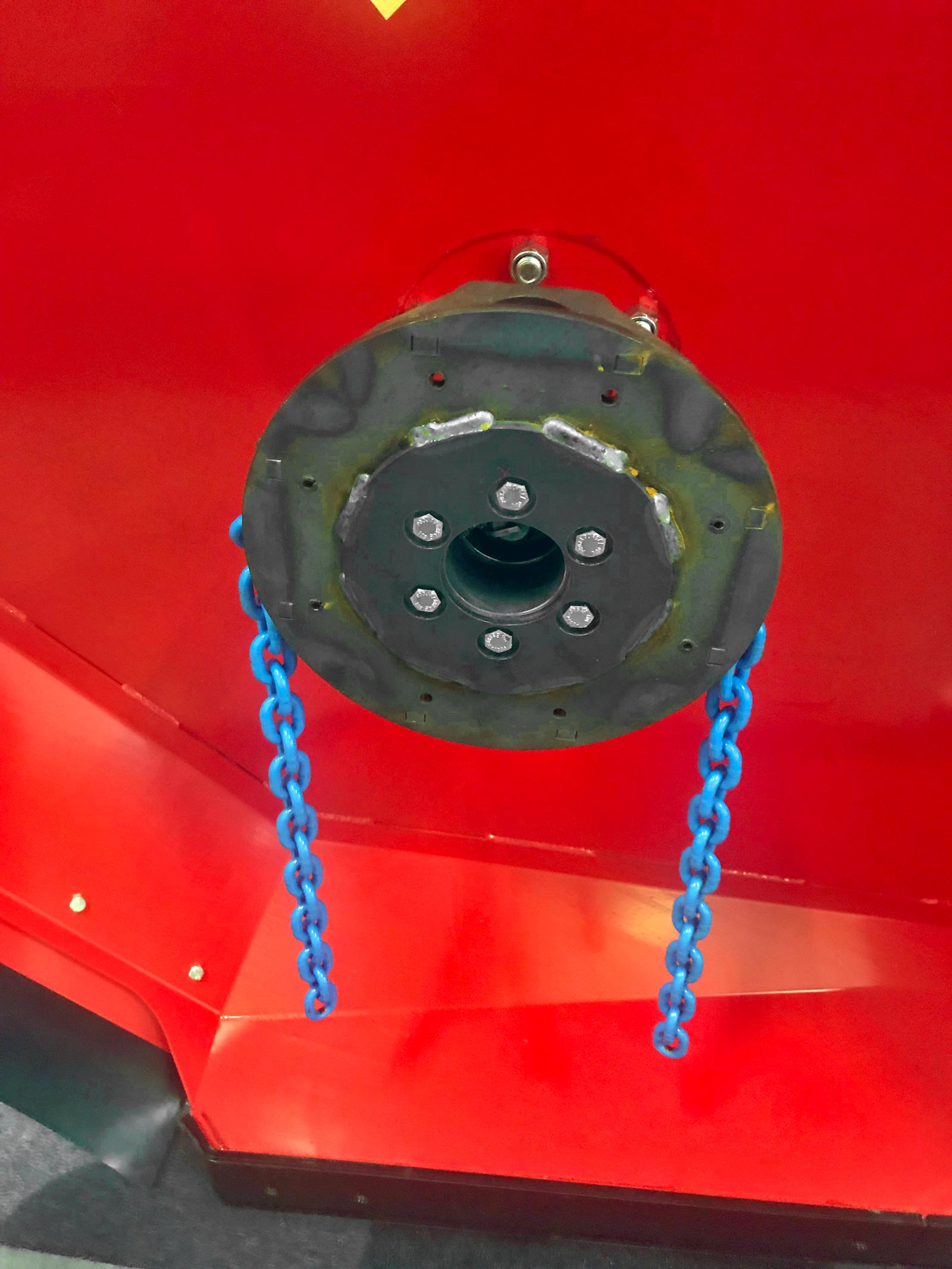 En rød skærm og et sort metalaksel med blå kæder fastgjort til