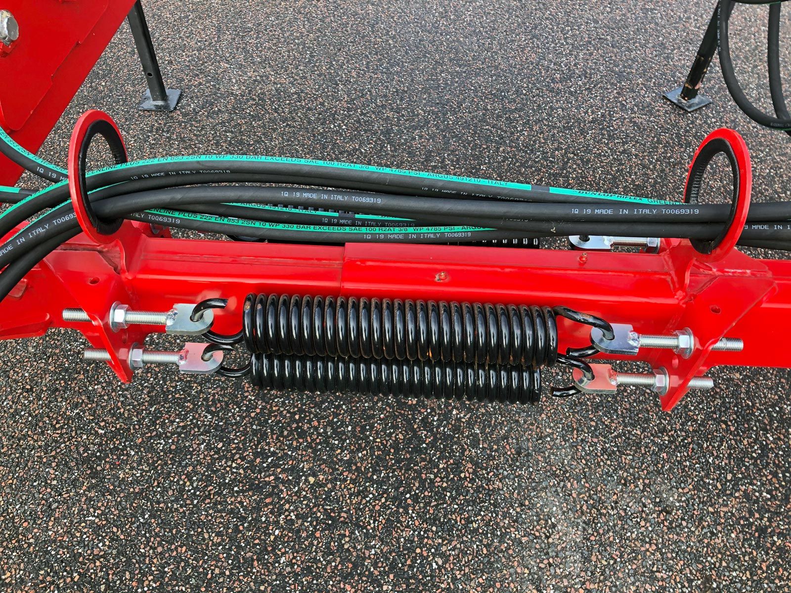 En rød maskine med en masse slanger knyttet til det samt 2 sorte fjedre