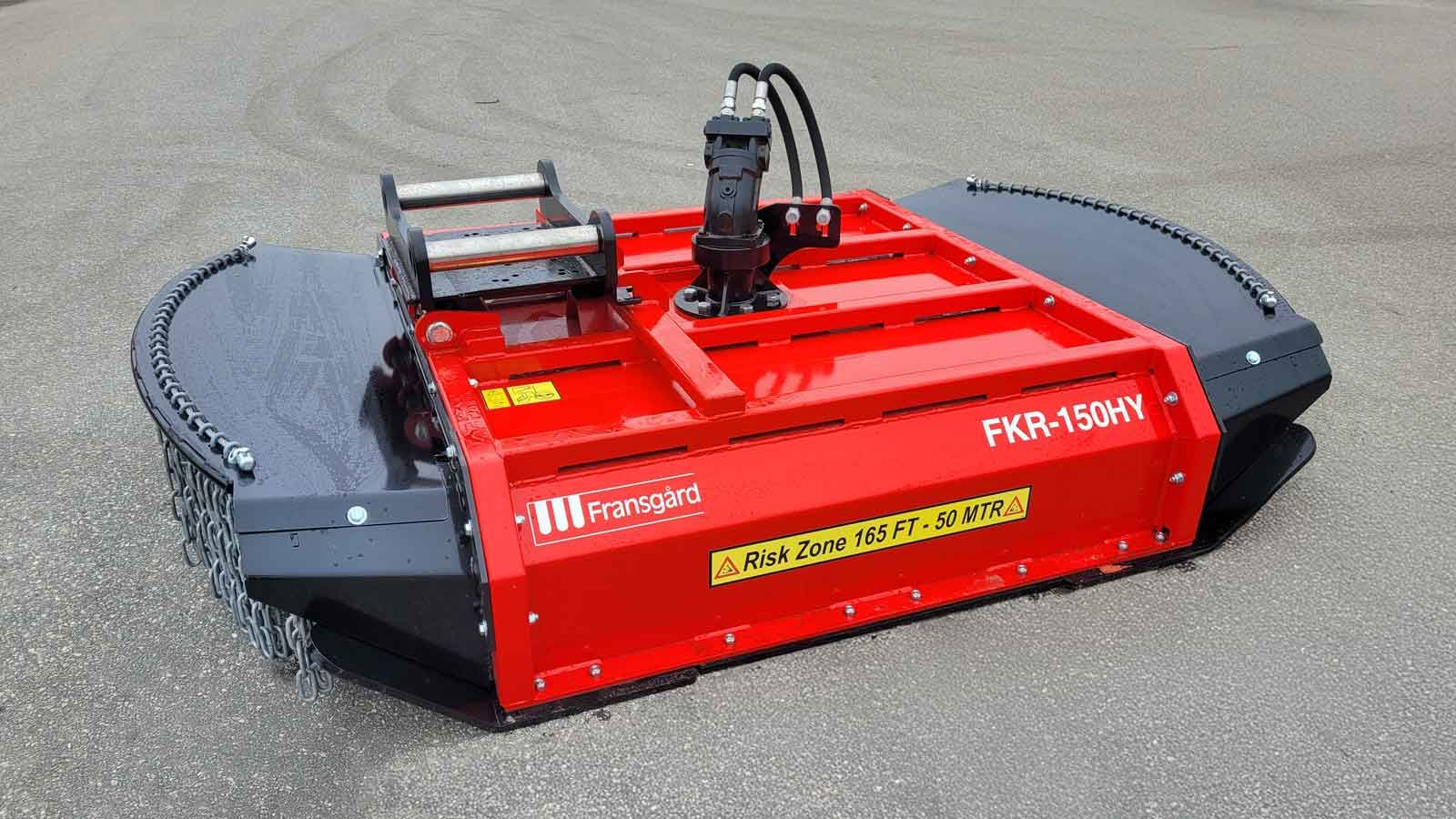 En traktor med kæderydder slår græs og krat i skoven