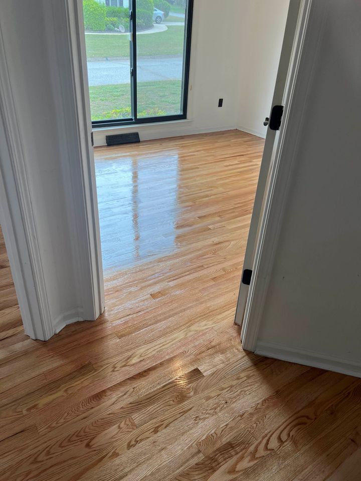 Empty room with hardwood floors and a sliding glass door leading outside