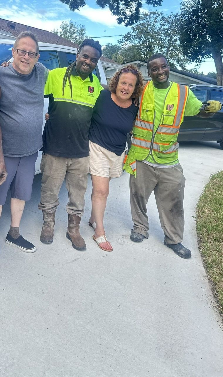 Two Concrete Renovations personnel pose in a photo with two customers smiling