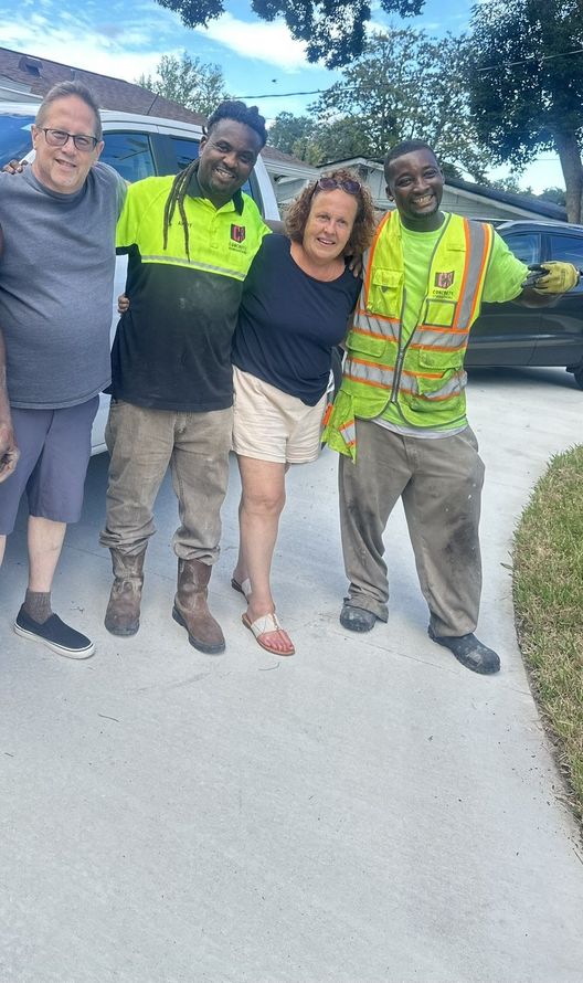 Two Concrete Renovations personnel pose in a photo with two customers smiling