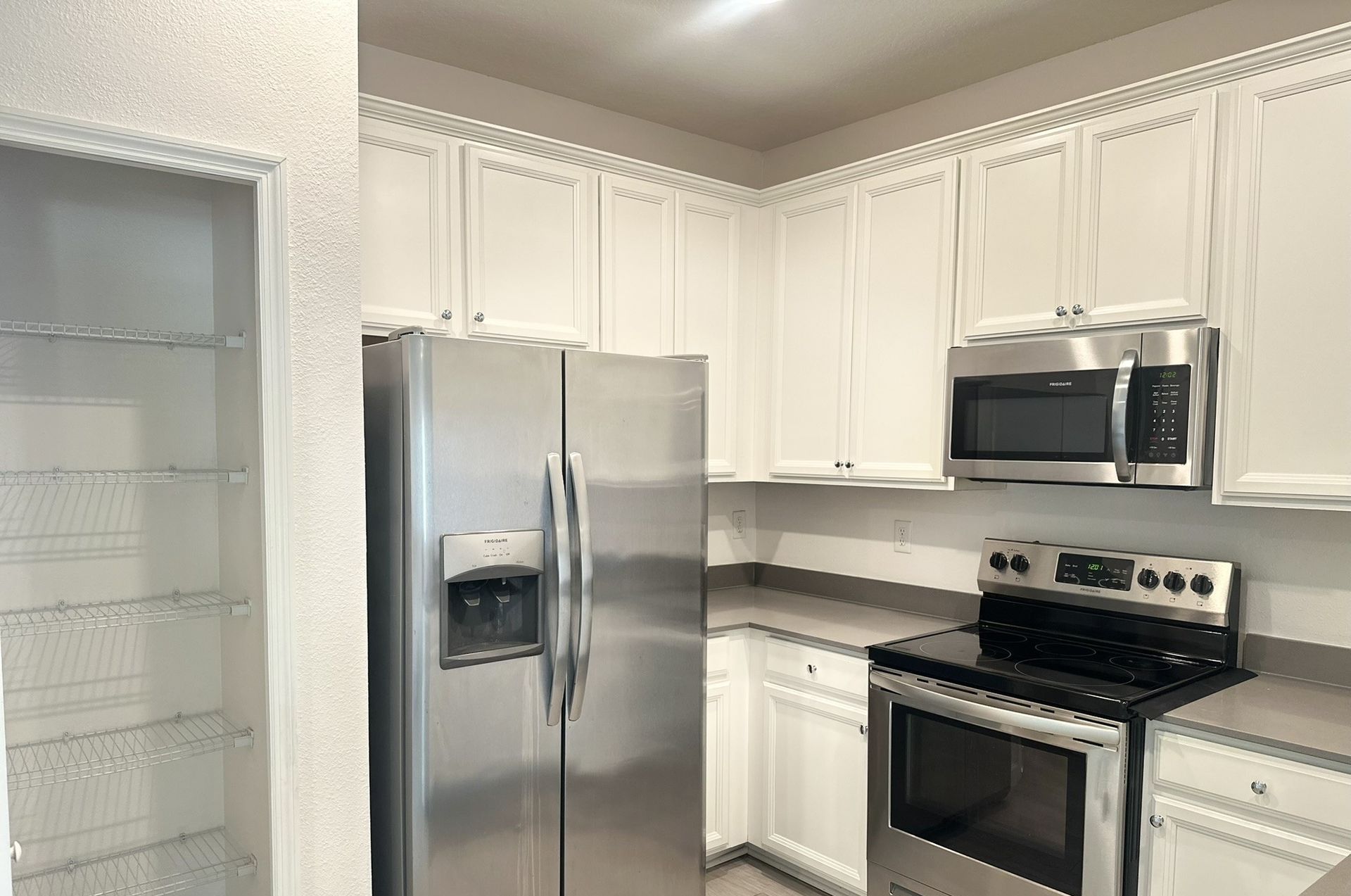 Kitchen with white cabinets, stainless steel appliances, and a pantry.