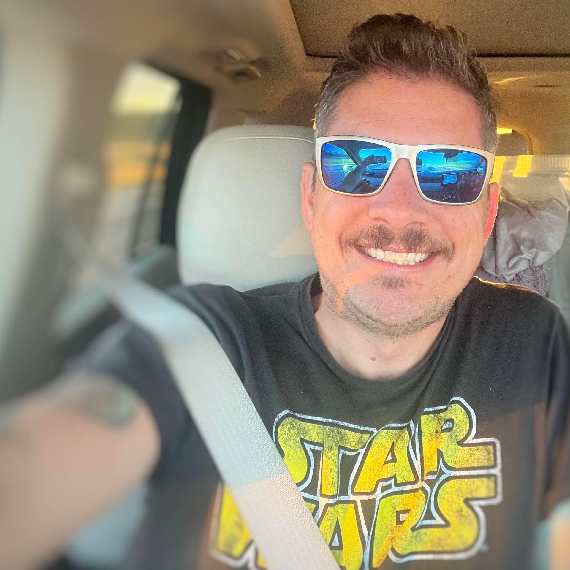 A man wearing sunglasses and a star wars shirt
