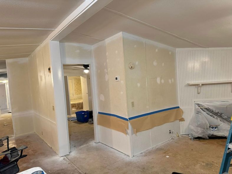 A room with white walls and a blue tape on the wall.