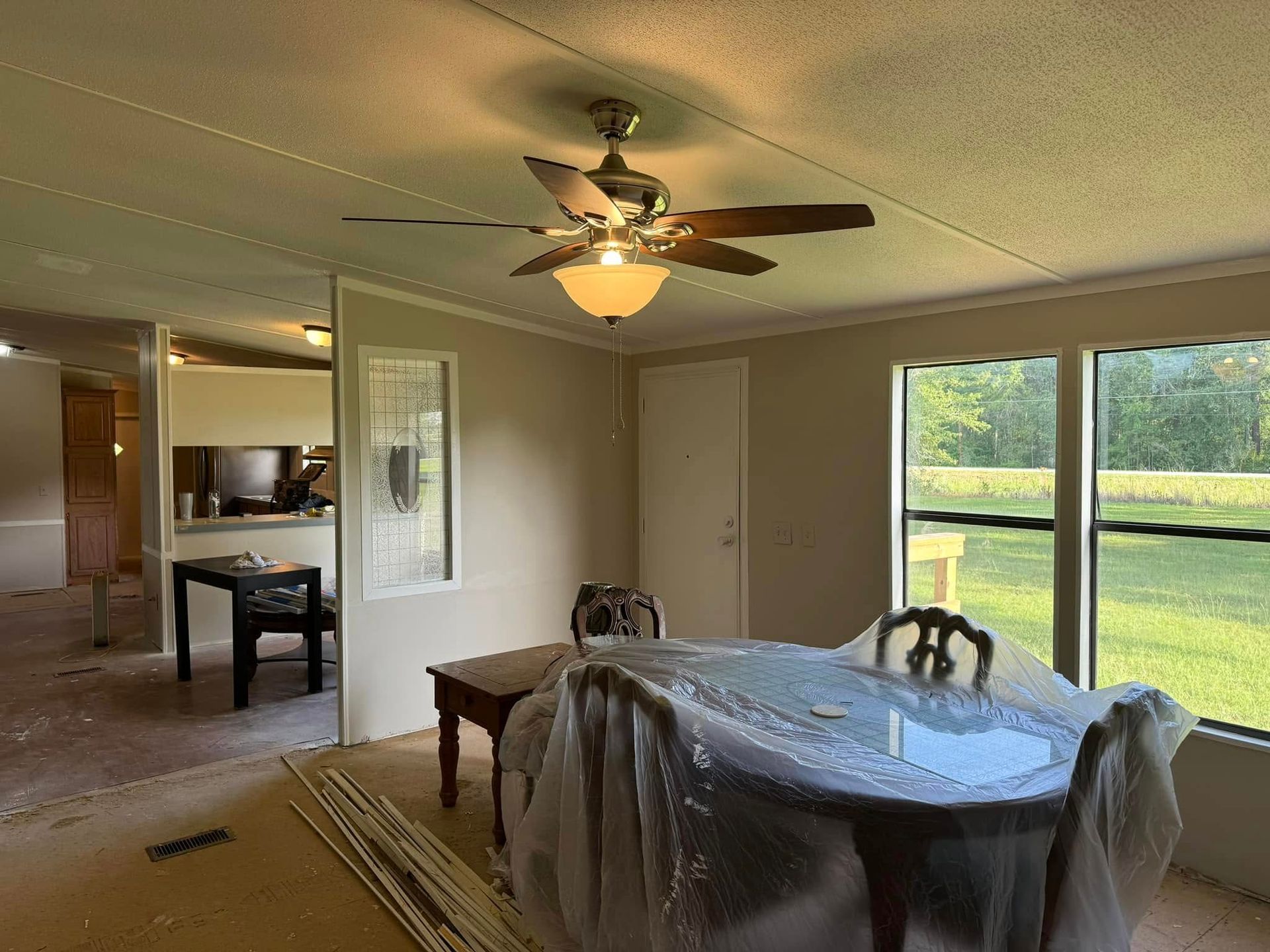 A dining room with a table and chairs and a ceiling fan.