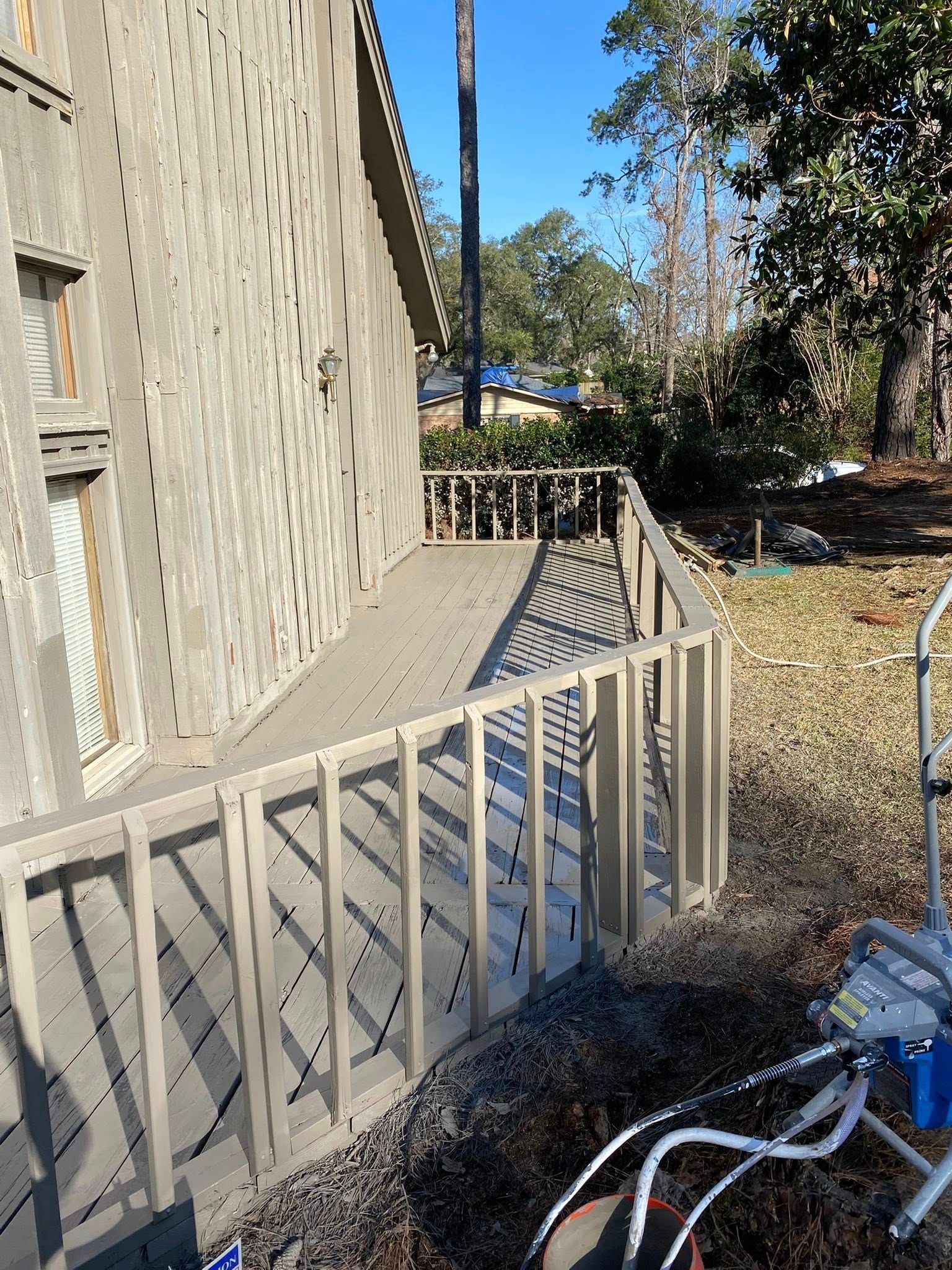A house with a wooden deck and stairs leading up to it.