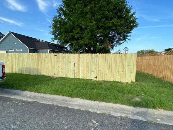 A truck is parked in front of a wooden fence.