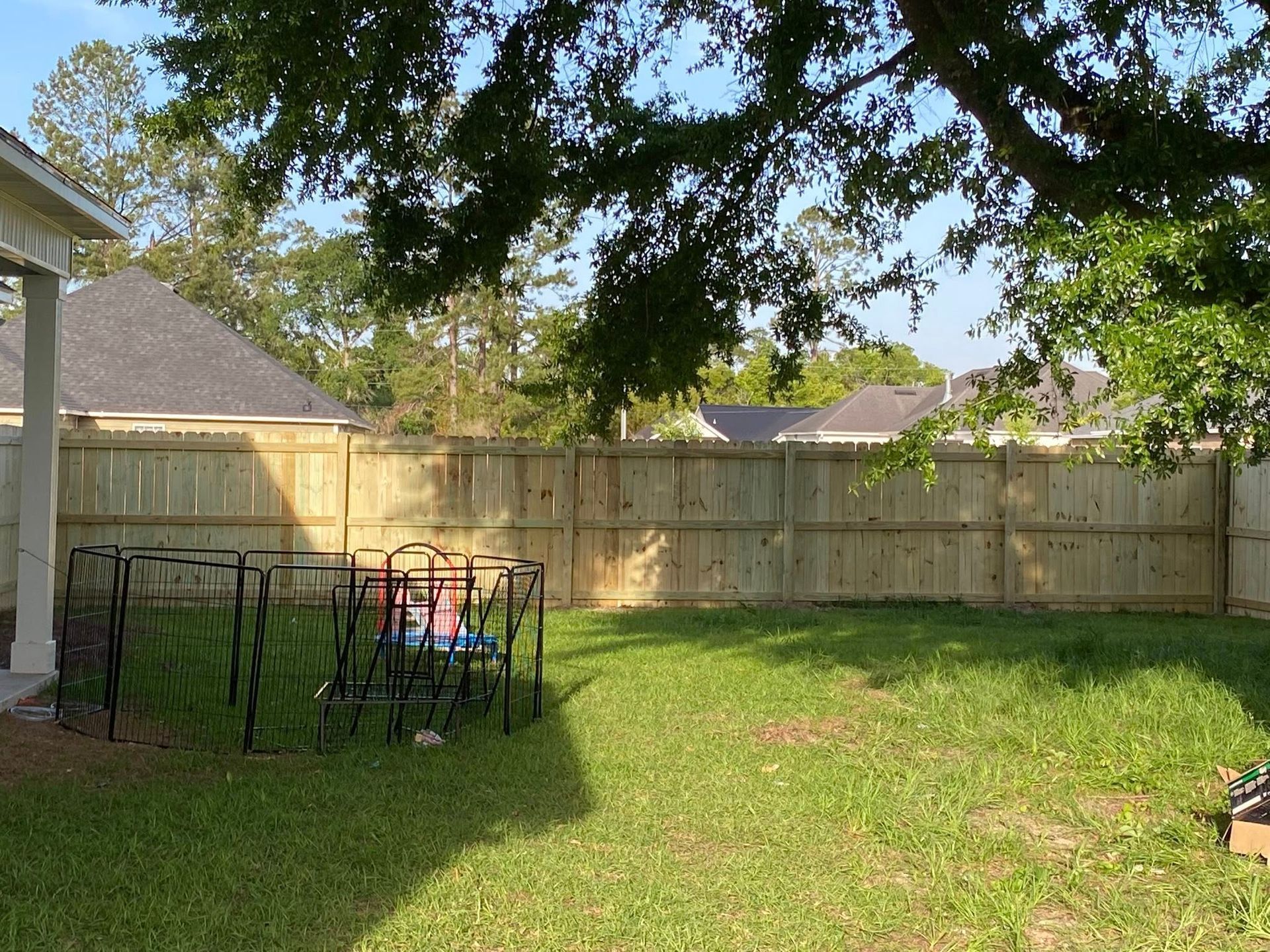 A backyard with a wooden fence and a swing set.