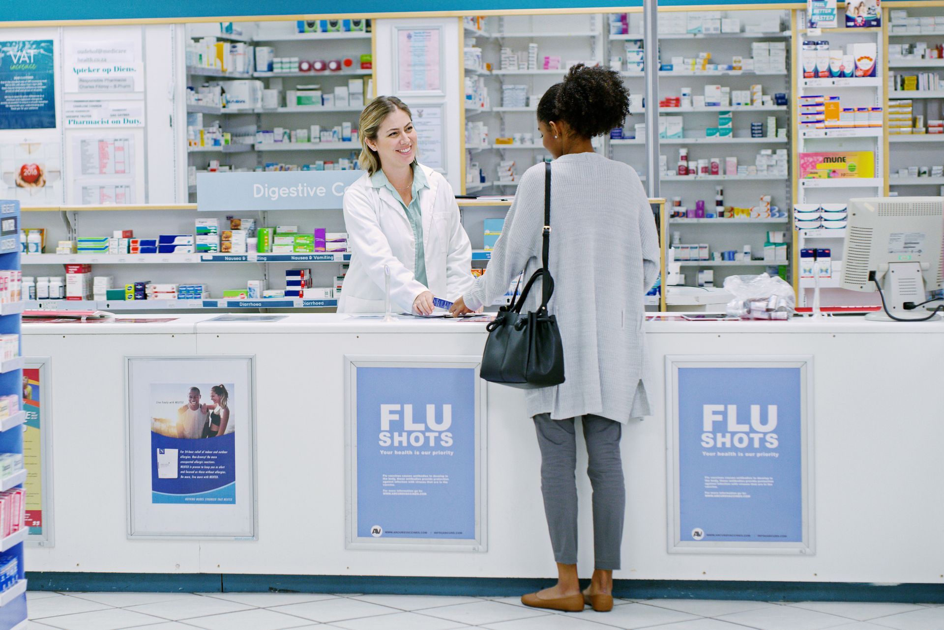 Pharmacist smiles at customer in pharmacy; 