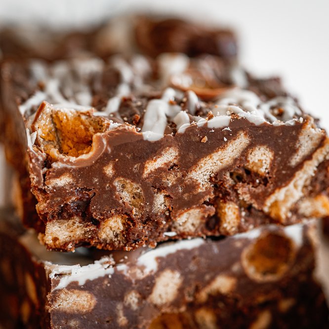 Chocolate biscuit cake, layered, showing biscuits and chocolate icing.