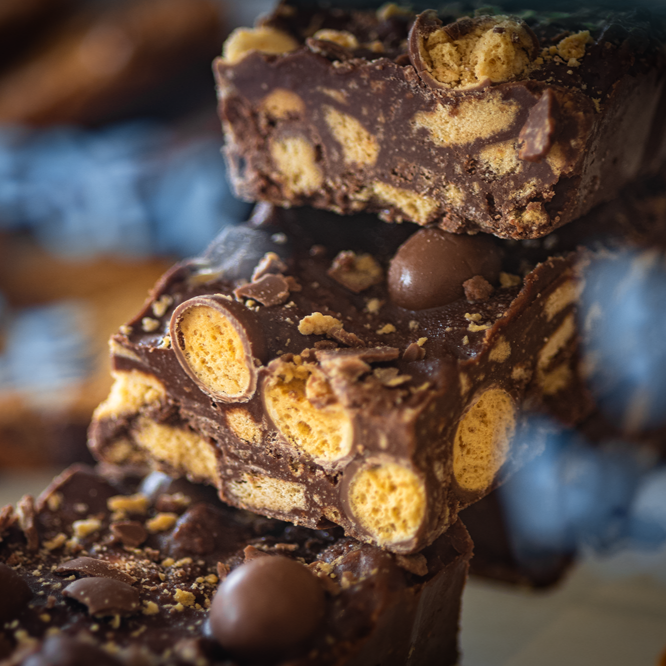 Chocolate rocky road dessert stacked, with honeycomb, and chocolate candy.