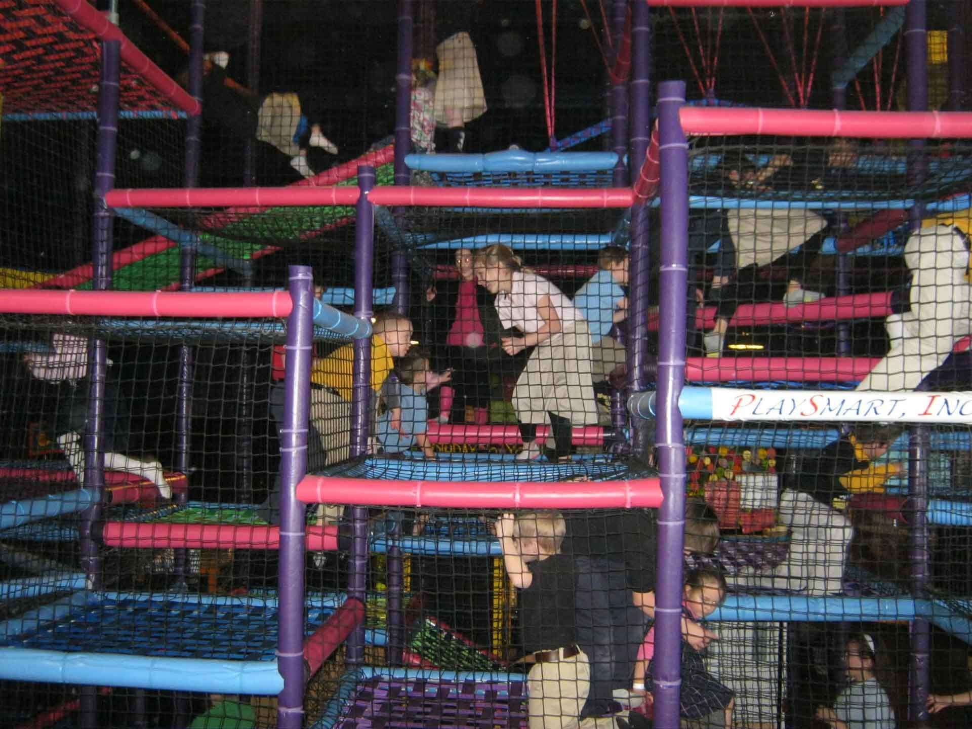 A group of children are playing in a playground with a sign that says play smart