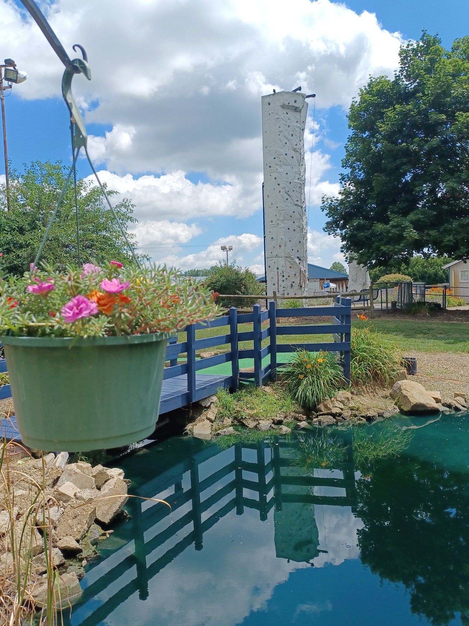 A pond with a climbing wall in the background