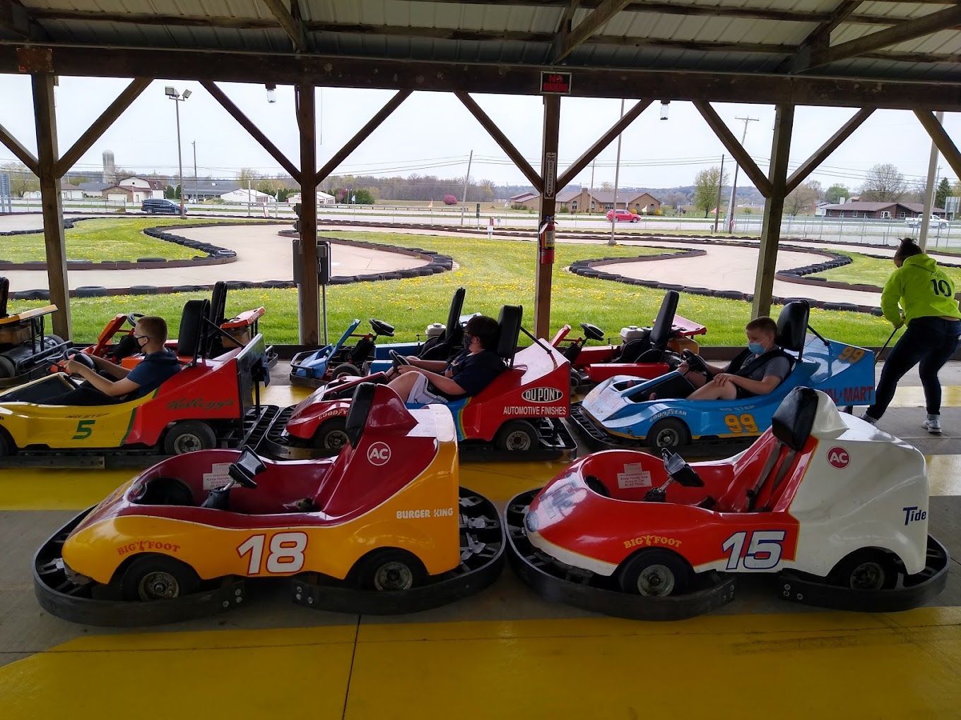 A group of people are riding go karts on a track.