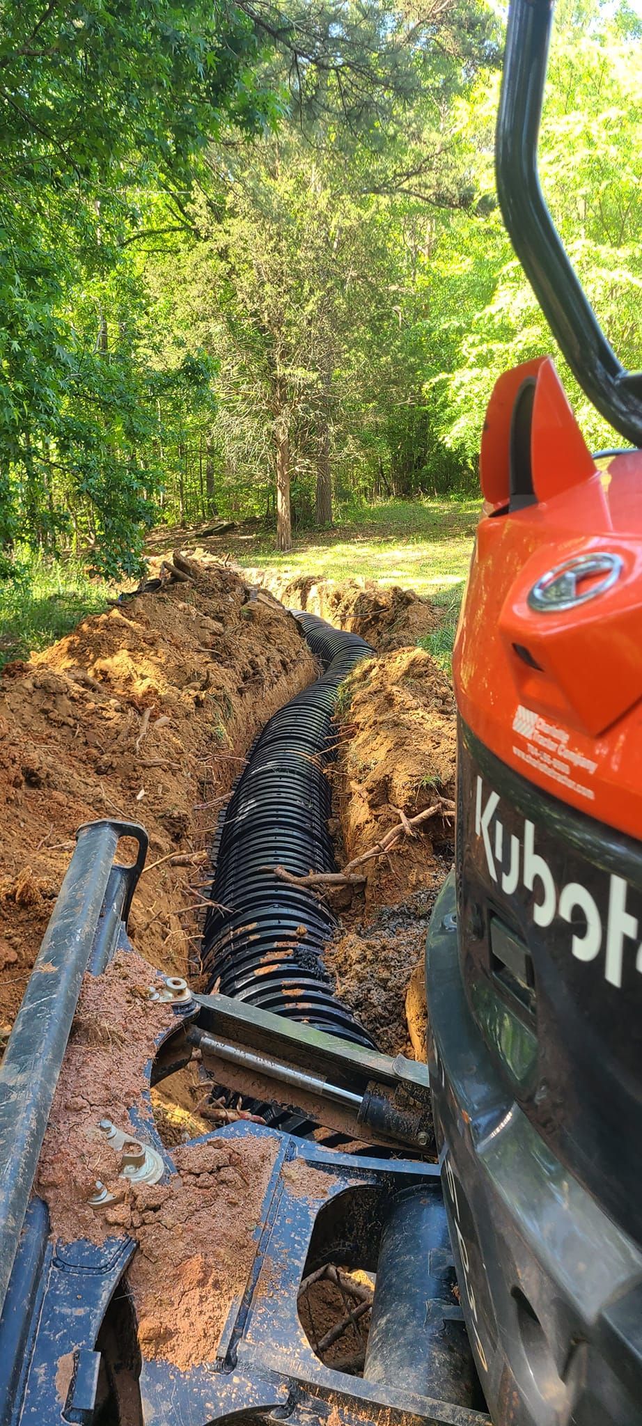 A bulldozer is digging a trench in the dirt.