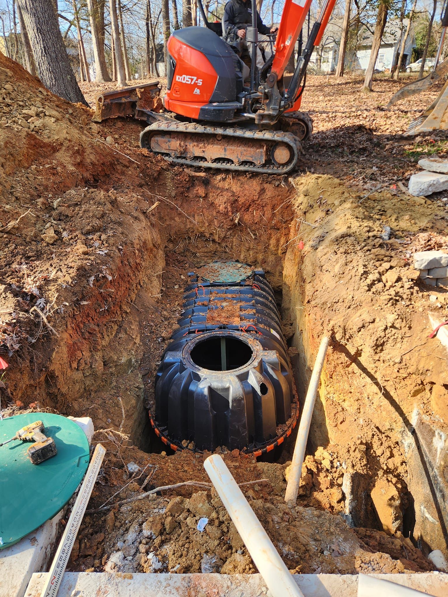 A large tank is being installed in a hole in the ground.