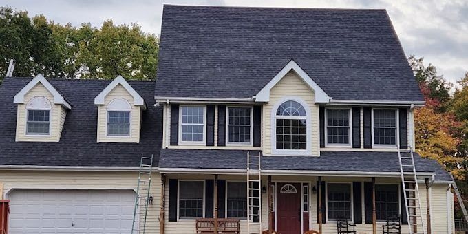 A large house with a blue roof and white trim