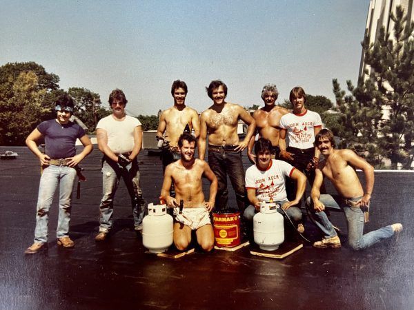 A group of men are posing for a picture with propane tanks
