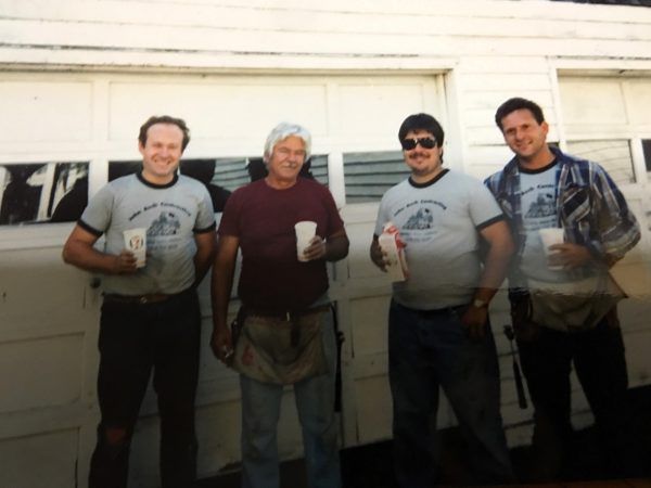 A group of men standing in front of a garage door