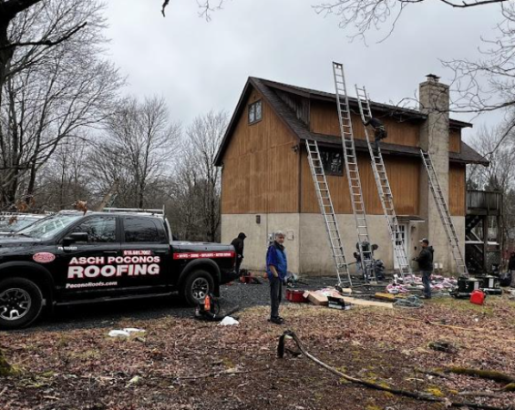 A roofing truck is parked in front of a house