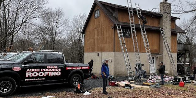 A roofing truck is parked in front of a house.
