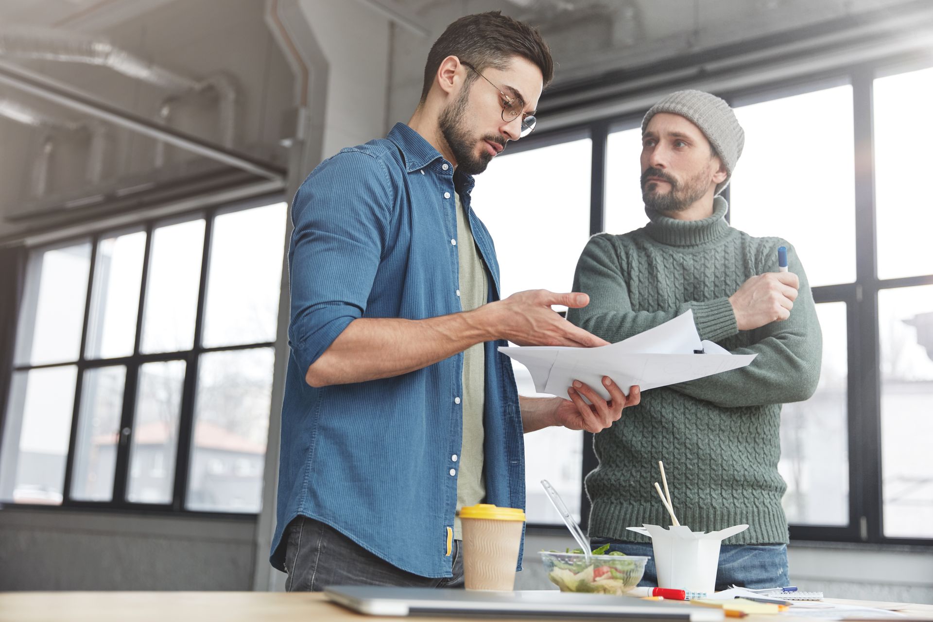 A green house with a gray roof and yellow trim