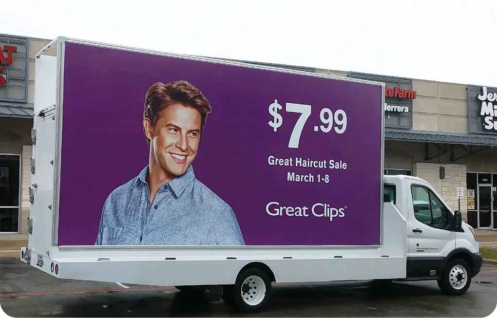 A white van with a purple billboard on the side of it advertising great clips.