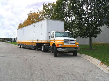 an orange and white semi truck is parked on the side of the road