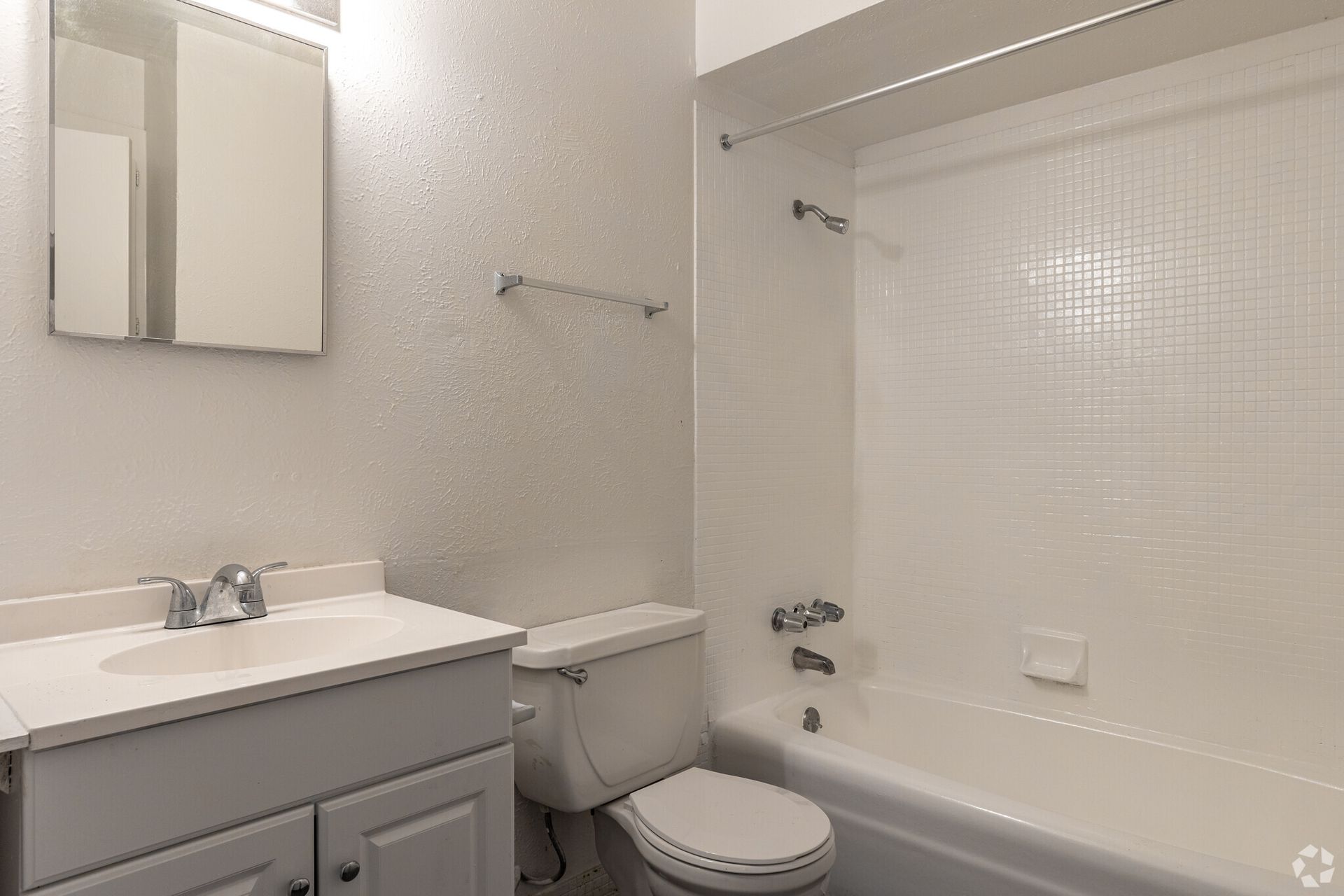 A bathroom with a sink , toilet , bathtub and mirror.