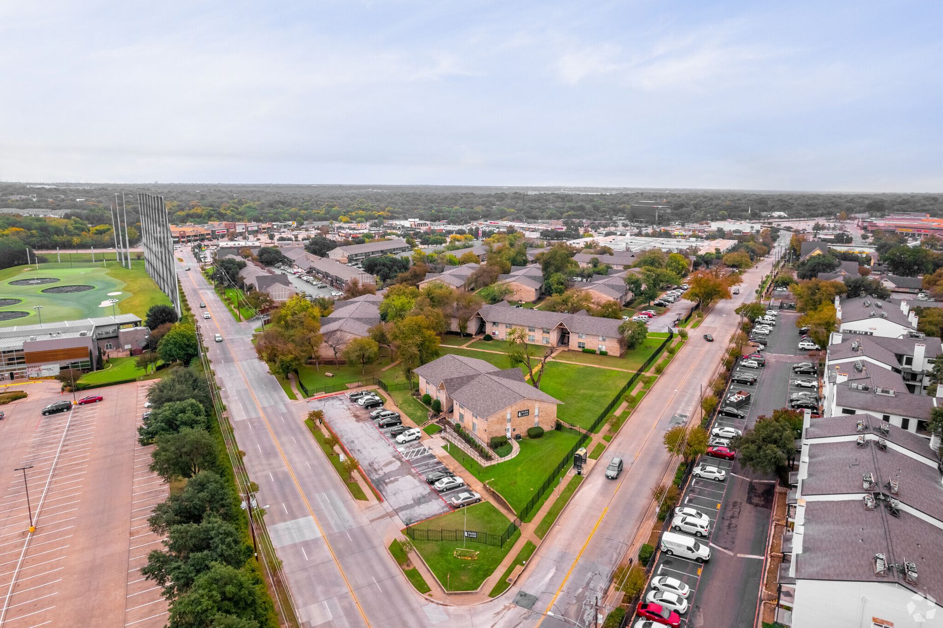 An aerial view of a residential area with a baseball field in the background.