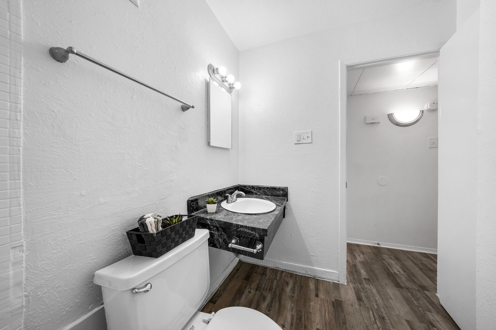 A bathroom with a toilet , sink and mirror.