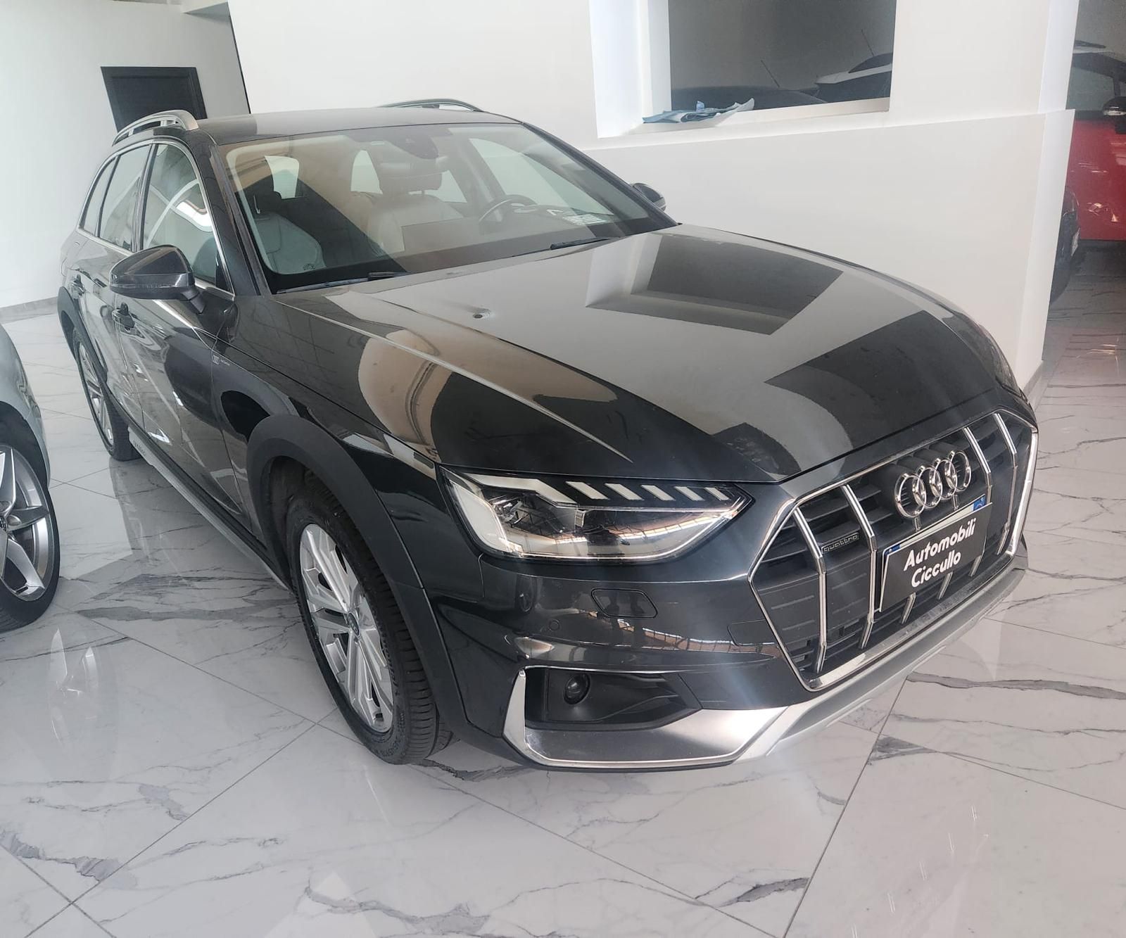 una persona tiene in mano le chiavi davanti a un'auto.