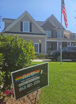 A house with a sign in front of it that says r & r paint contracting llc