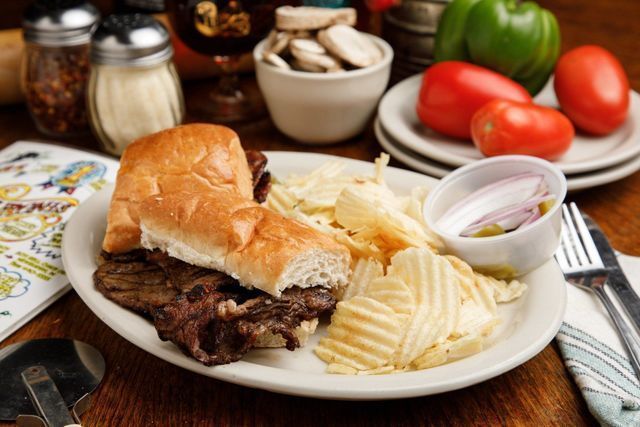 A plate of food with a sandwich and chips on a table.
