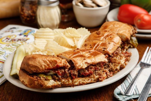 A plate of food with a sandwich and potato chips on a table.