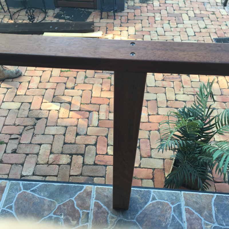 A brick patio with a wooden railing and a palm tree — DC Fencing In Wondunna, QLD