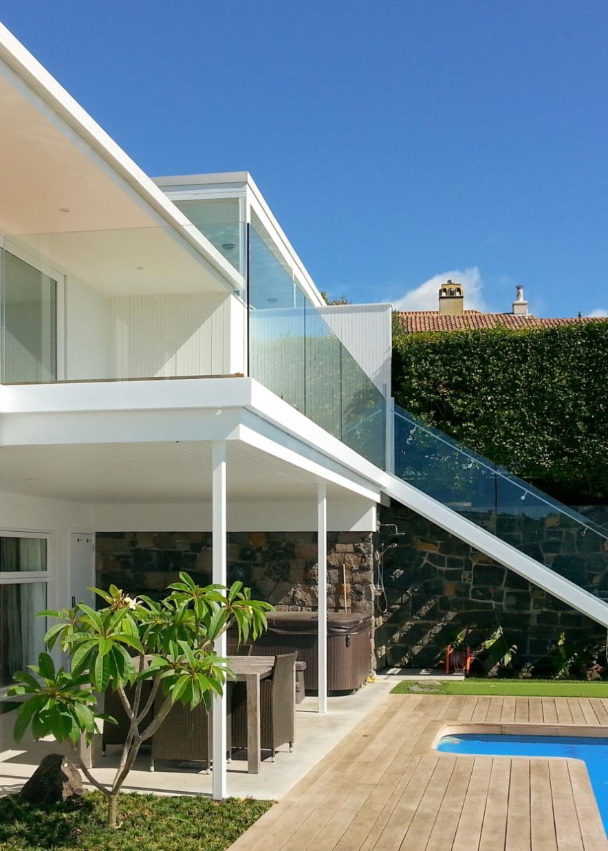 A Large White House With a Swimming Pool in Front of It — DC Fencing In Wondunna, QLD