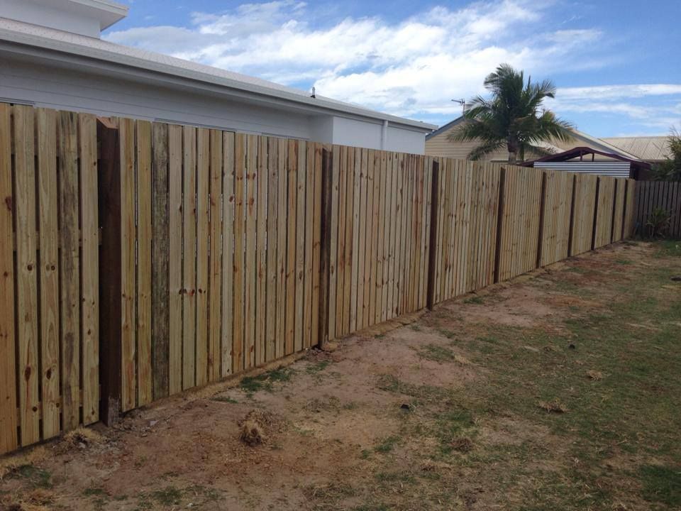 A Wooden Fence is in the Backyard of a House — DC Fencing In Wondunna, QLD