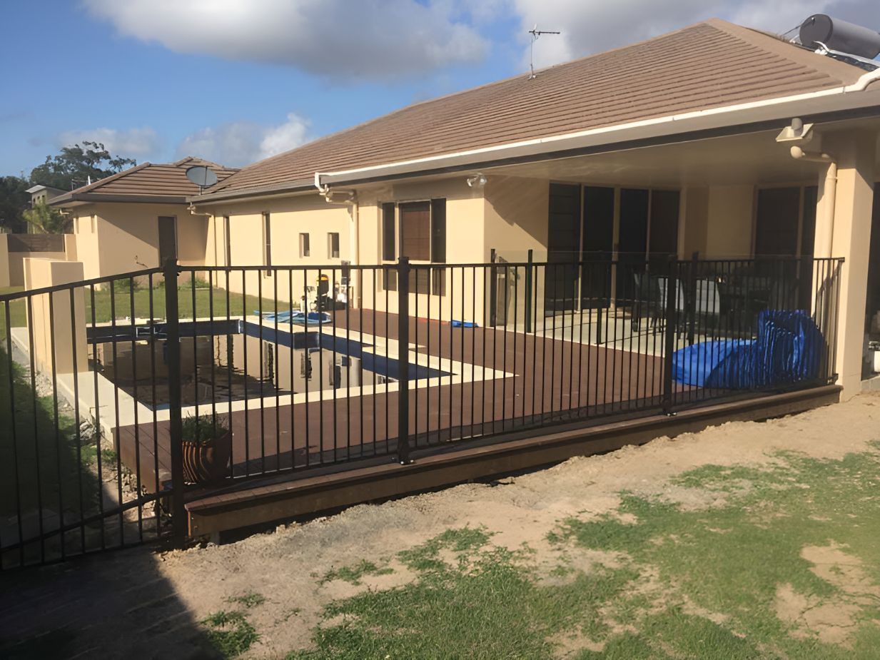 A House With a Fence Around It and a Swimming Pool in the Backyard — DC Fencing In Wondunna, QLD