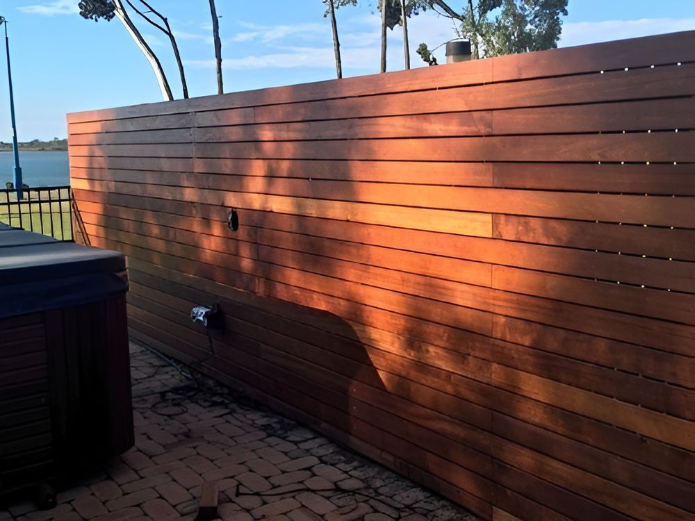 A Wooden Fence With a Hot Tub in the Background — DC Fencing In Wondunna, QLD
