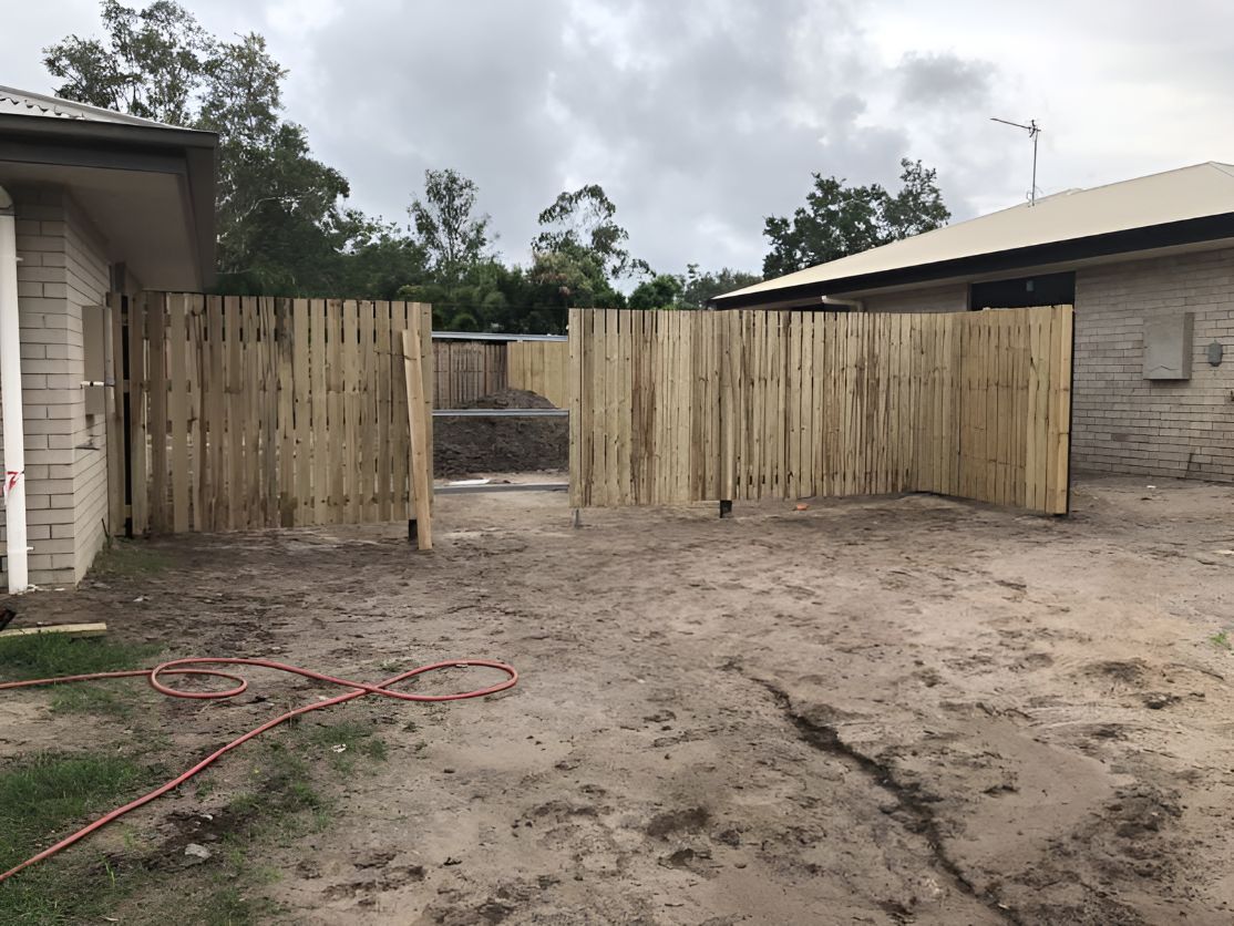 A Wooden Fence is Being Built in Front of a House — DC Fencing In Wondunna, QLD