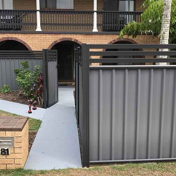 A fence with a gate in front of a brick house. — DC Fencing In Wondunna, QLD