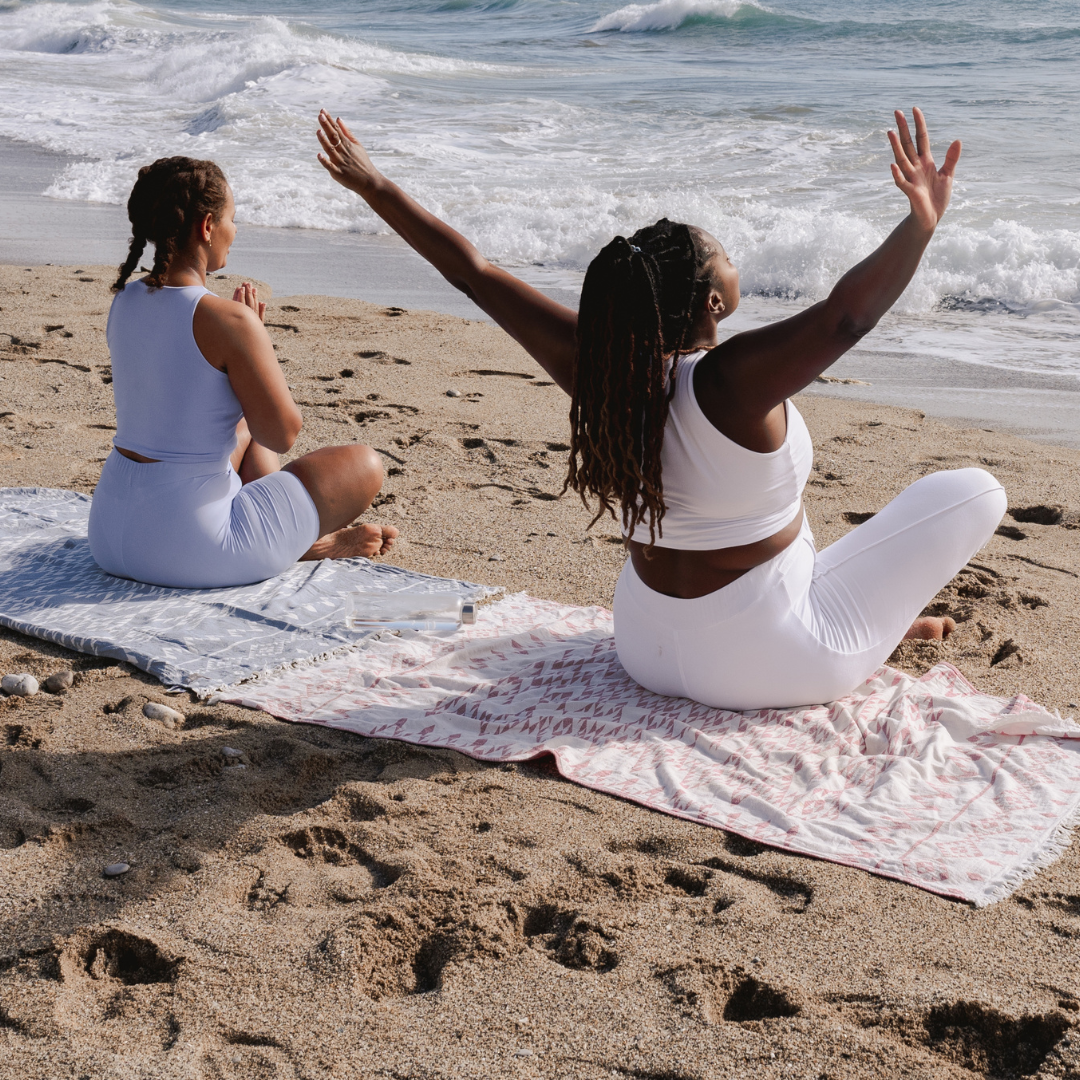 Two women practice mindfulness on the beach 