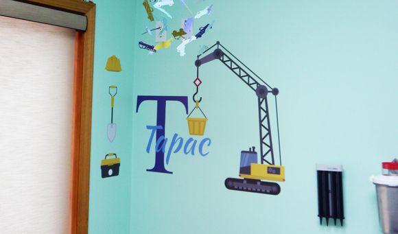 A wall with a crane and the letter T on it.