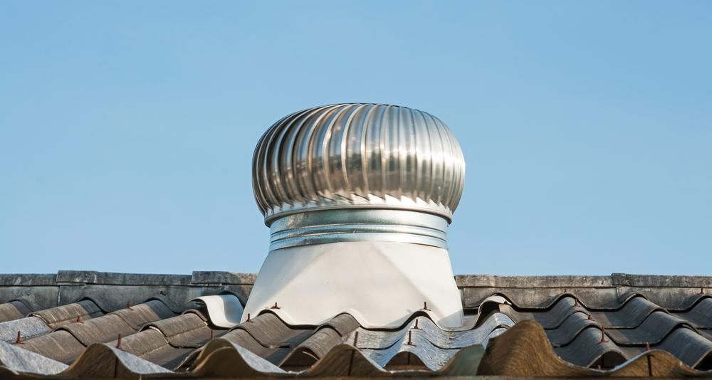 Metallic Roof Turbine Vent on a Dark Gray, Corrugated Roof Against a Clear Blue Sky — Boostn Pty Ltd in Glastonbury, QLD