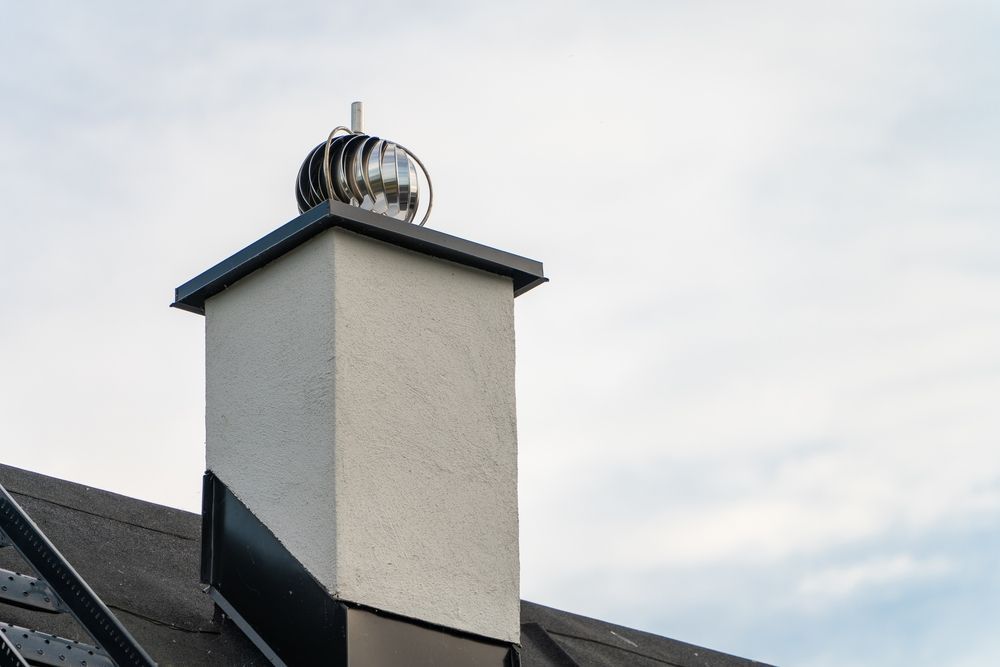 White Chimney With a Spinning Cap on a Dark Roof Against a Cloudy Sky — Boostn Pty Ltd in Sunshine Coast, QLD