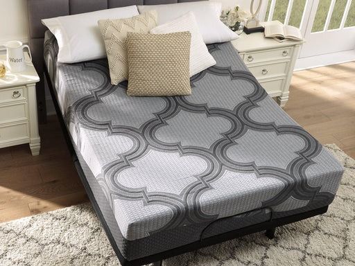 Gray mattress with a patterned cover, pillows, and nightstands in a bedroom setting.